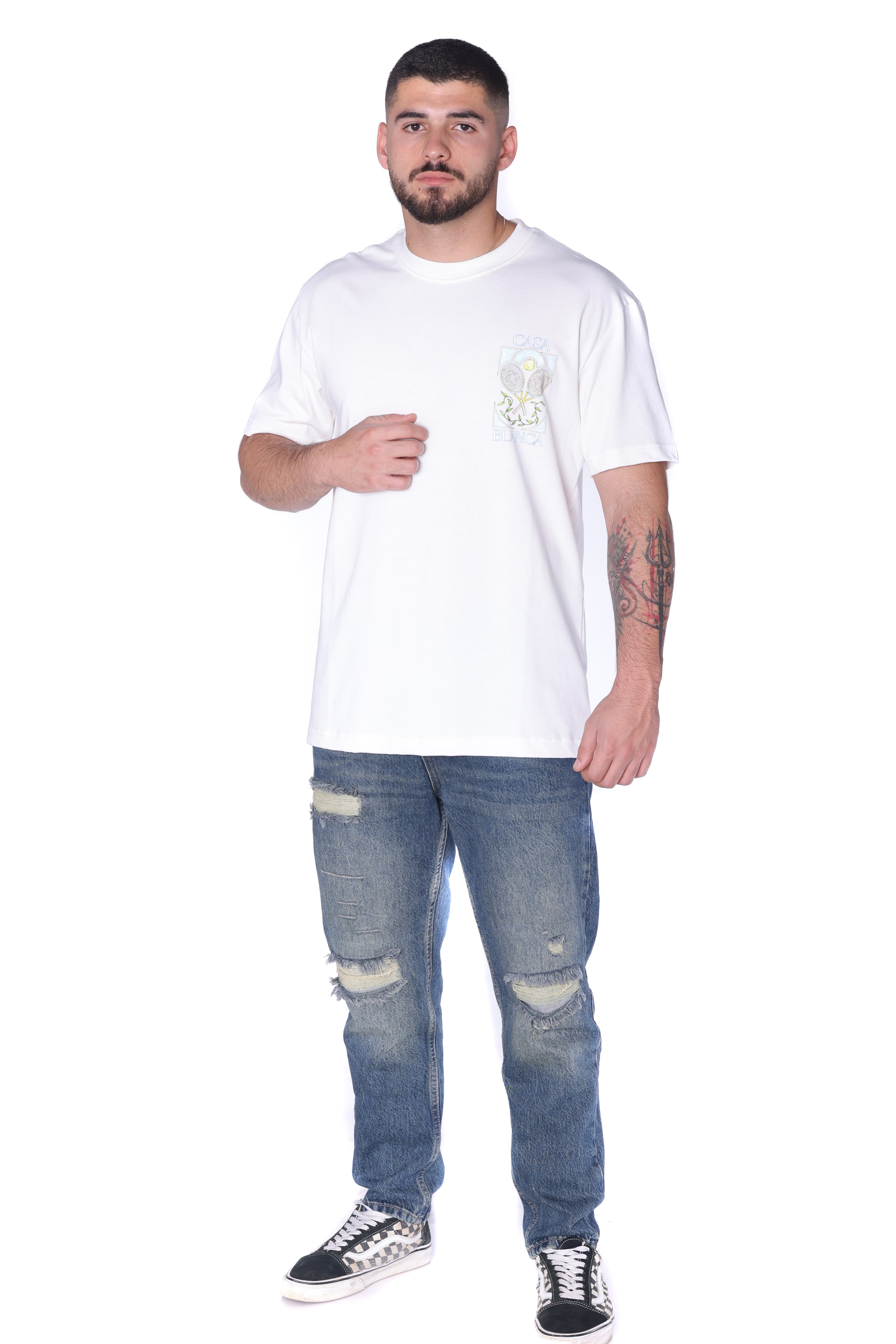 White Oversized T-Shirt Casa Blanca Tennis - Clean white oversized t-shirt featuring a subtle front chest graphic and bold Casa Blanca-inspired artwork on the back with tennis racket design details. Made from soft breathable fabric with a relaxed fit for all-day comfort. A fresh premium streetwear piece perfect for casual summer looks and everyday styling.