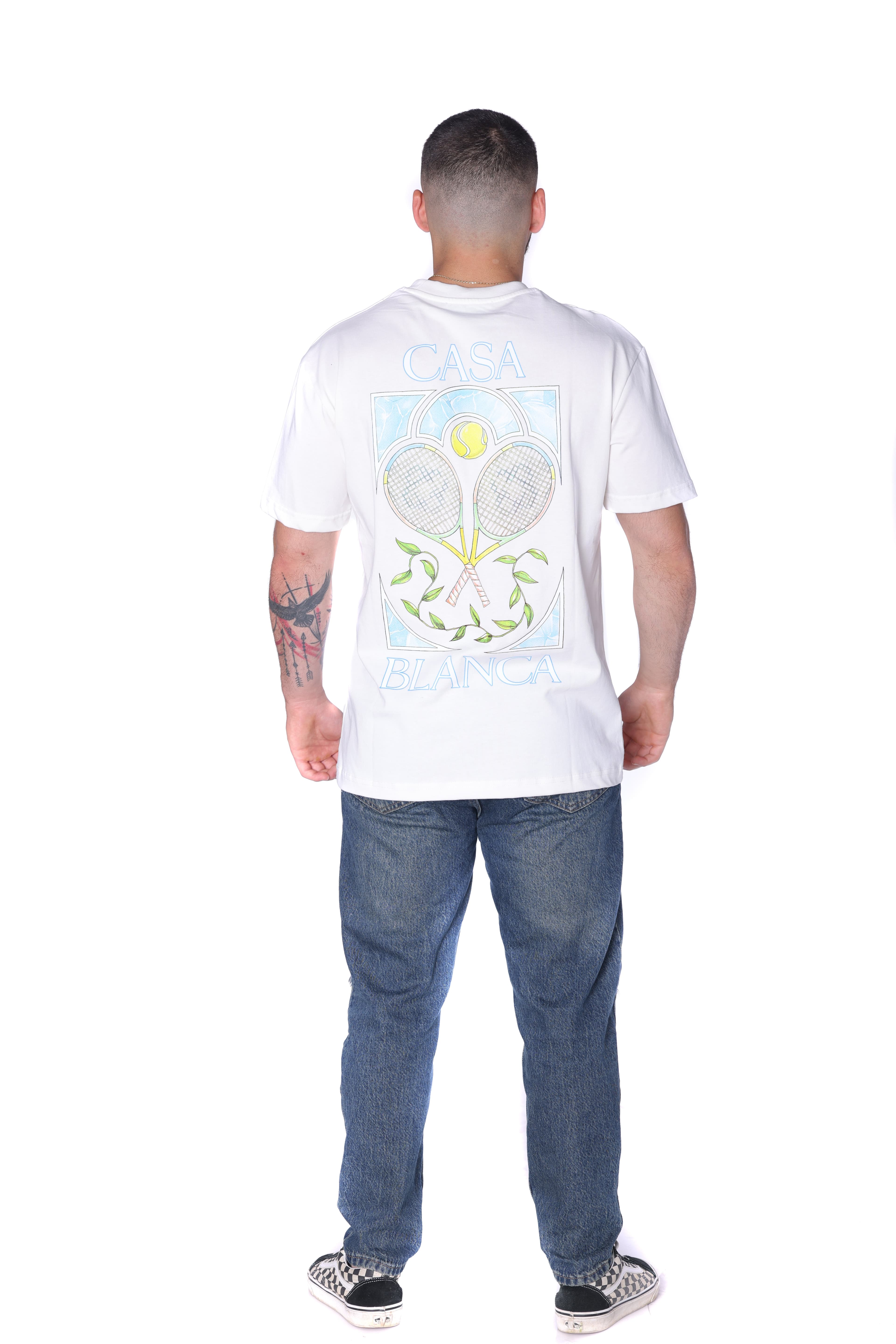 White Oversized T-Shirt Casa Blanca Tennis - Clean white oversized t-shirt featuring a subtle front chest graphic and bold Casa Blanca-inspired artwork on the back with tennis racket design details. Made from soft breathable fabric with a relaxed fit for all-day comfort. A fresh premium streetwear piece perfect for casual summer looks and everyday styling.