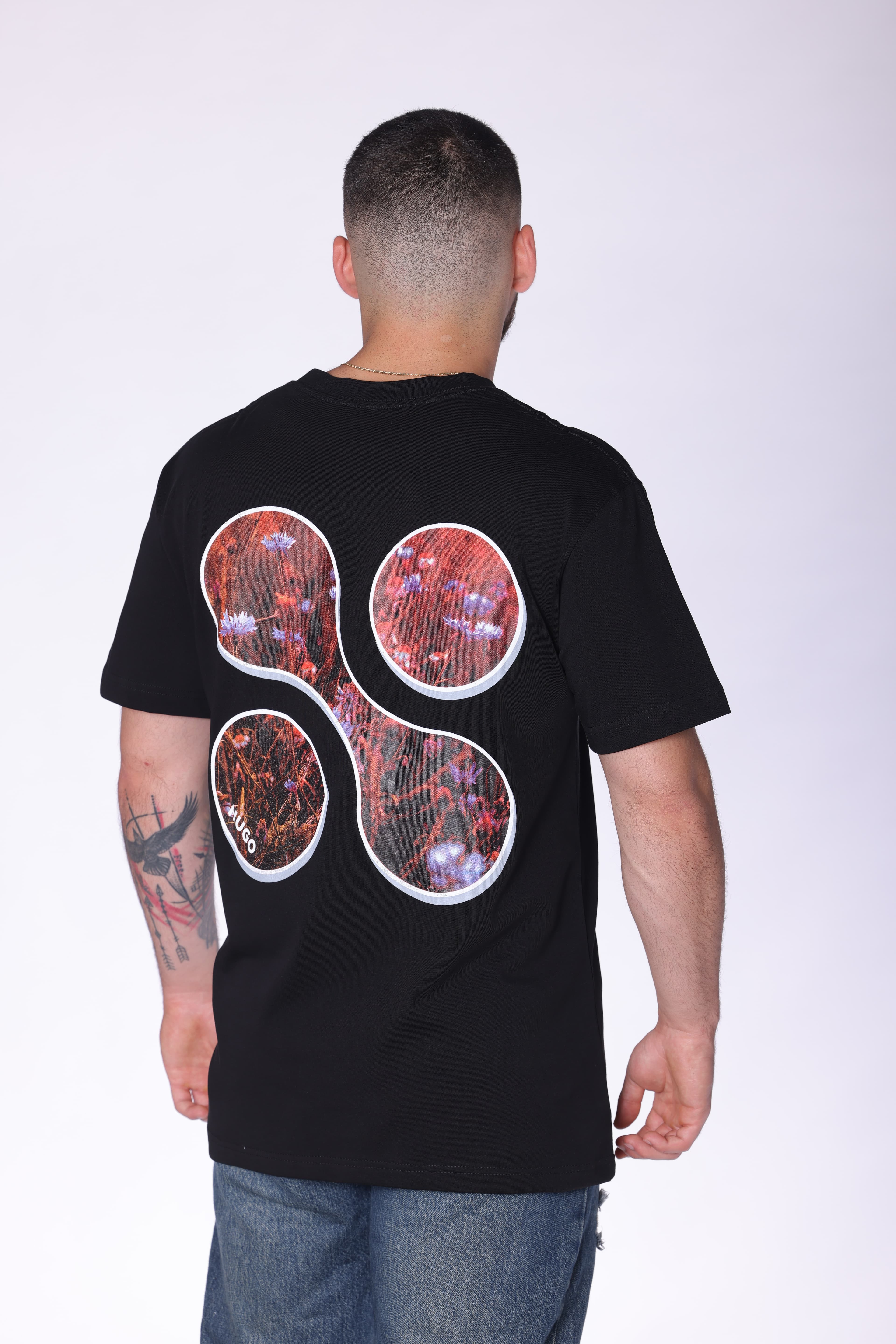 Black Oversized Forever Inspired T-Shirt Hugo Boss - Black oversized t-shirt featuring a subtle front chest graphic and bold abstract floral artwork on the back. Crafted from soft breathable fabric with a relaxed fit for all-day comfort. A clean statement streetwear piece perfect for casual styling, layered looks, and everyday wear.