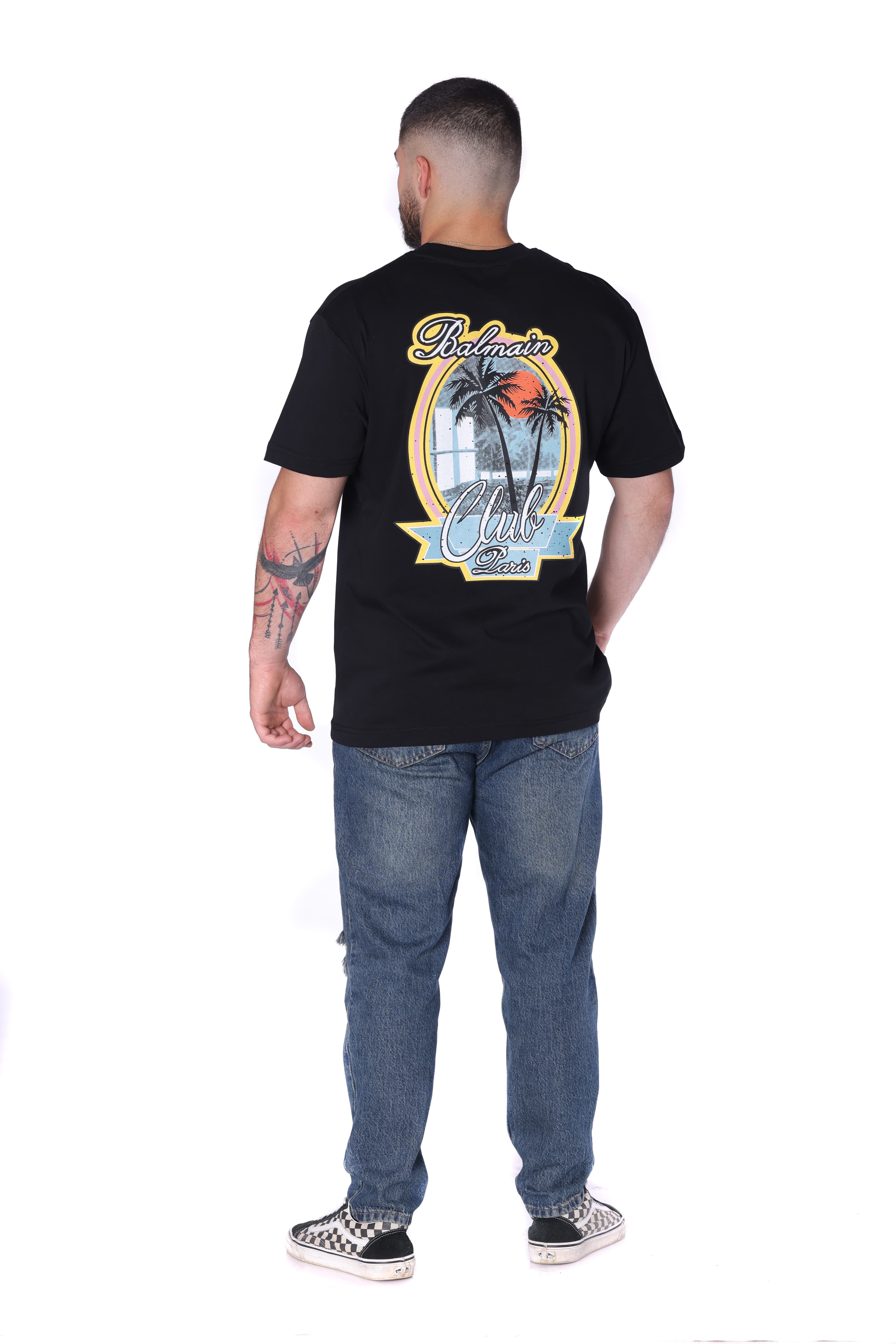 Black Balmain Club Oversized T-Shirt - Black oversized t-shirt featuring a minimal front chest logo and bold Balmain Club Paris-inspired artwork on the back with tropical sunset design details. Made from soft breathable fabric with a relaxed fit for everyday comfort. A standout luxury streetwear piece perfect for summer outfits, casual styling, and elevated everyday wear.