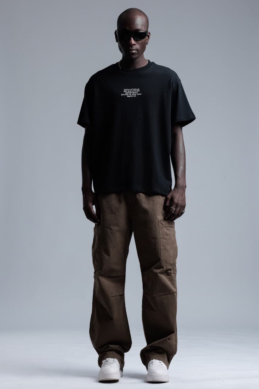 Oversized Black T-Shirt Catch Studios - Oversized black t-shirt featuring clean embroidered front text detail for a minimal premium look. Crafted from soft breathable fabric with a relaxed fit for all-day comfort. A timeless streetwear essential perfect for casual outfits, layered styling, and everyday wear.