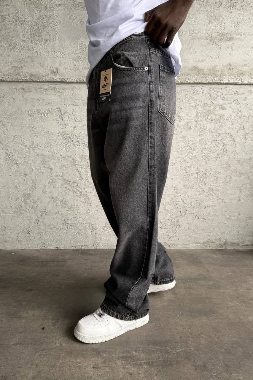 Relaxed Fit Baggy Jeans Charcoal Black - Relaxed fit baggy jeans in a washed charcoal black denim finish, featuring a loose straight-leg silhouette for a bold streetwear vibe. Made from durable premium denim with classic five-pocket styling and a comfortable oversized fit. Easy to pair with sneakers, hoodies, and oversized tees for an everyday urban look.