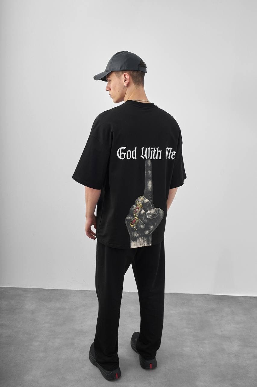 Oversized "god With Me" Black T-Shirt - Oversized black streetwear t-shirt featuring a clean minimal front logo and a bold statement back print with gothic “God With Me” text. Finished with a striking graphic hand design for an edgy urban look. Designed with a relaxed drop-shoulder fit, soft premium fabric, and loose silhouette for everyday comfort and style.