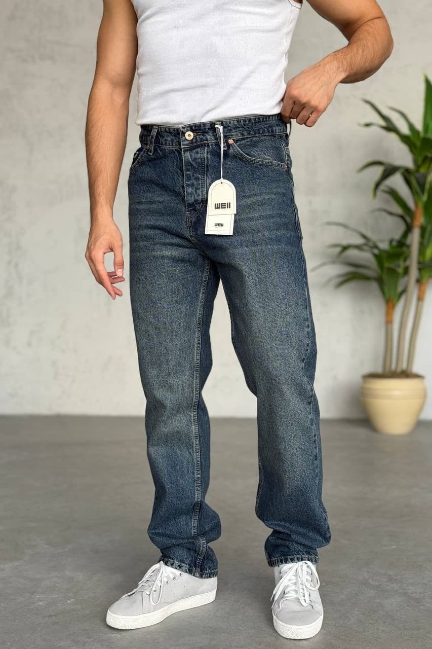 Medium Blue Wash Baggy Jeans - Baggy denim jeans in a medium blue wash, featuring a clean back design with minimal detailing for a timeless look. Designed with a regular fit that sits comfortably at the waist and offers a natural, relaxed fall through the leg. Finished with durable stitching and a soft yet sturdy denim feel—perfect for everyday wear and easy styling with sneakers or casual outfits.