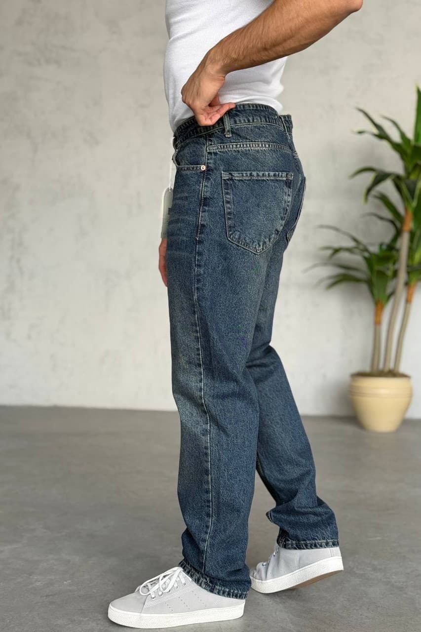 Medium Blue Wash Baggy Jeans - Baggy denim jeans in a medium blue wash, featuring a clean back design with minimal detailing for a timeless look. Designed with a regular fit that sits comfortably at the waist and offers a natural, relaxed fall through the leg. Finished with durable stitching and a soft yet sturdy denim feel—perfect for everyday wear and easy styling with sneakers or casual outfits.