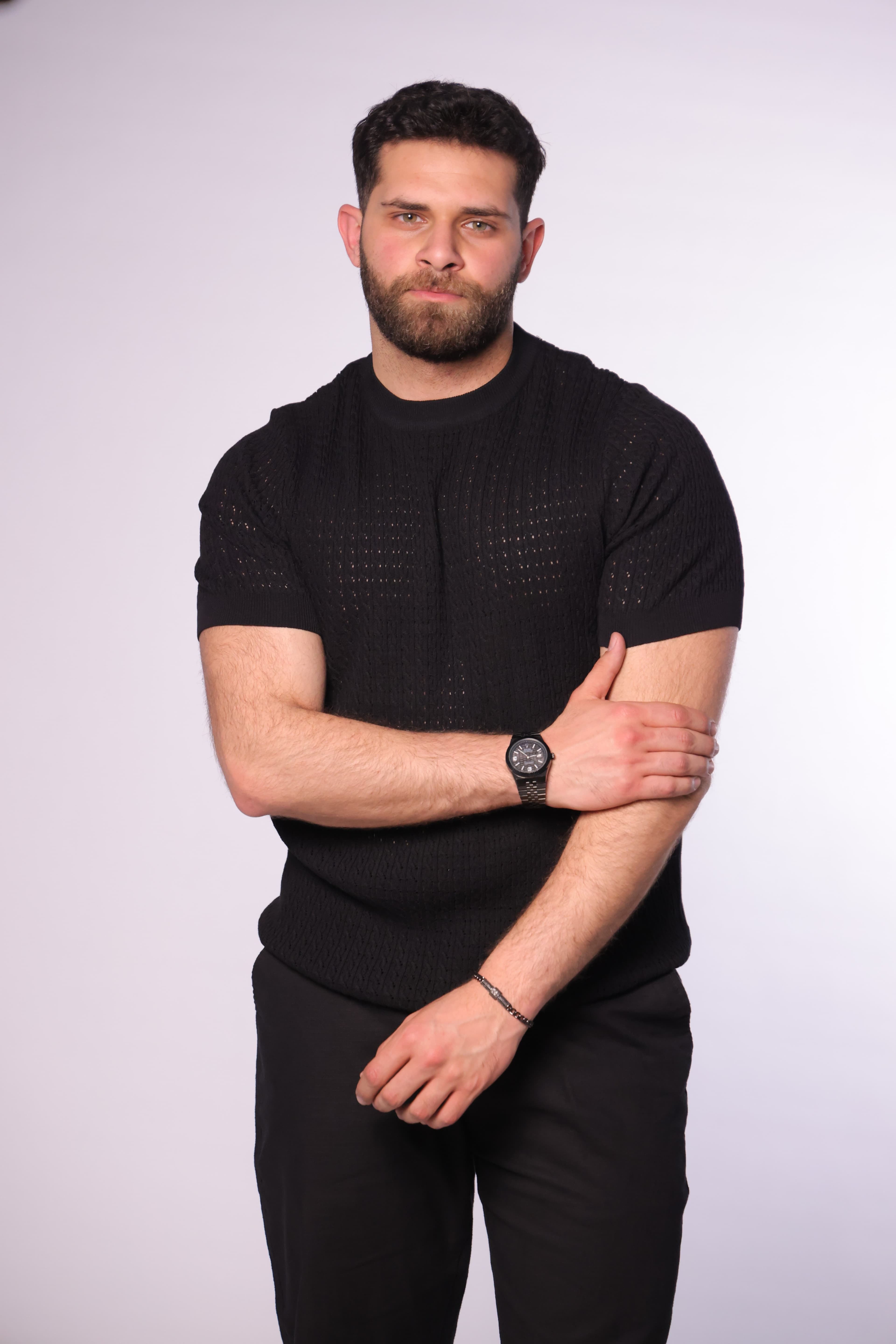 Slim-Fit Black Knitted T-Shirt - Slim-fit knitted t-shirt in an elegant black tone, featuring a textured patterned weave that adds depth and a premium feel. Designed with a clean crew neckline and fitted short sleeves that highlight the silhouette. Crafted from soft, breathable fabric, making it perfect for smart-casual looks or elevated everyday wear.