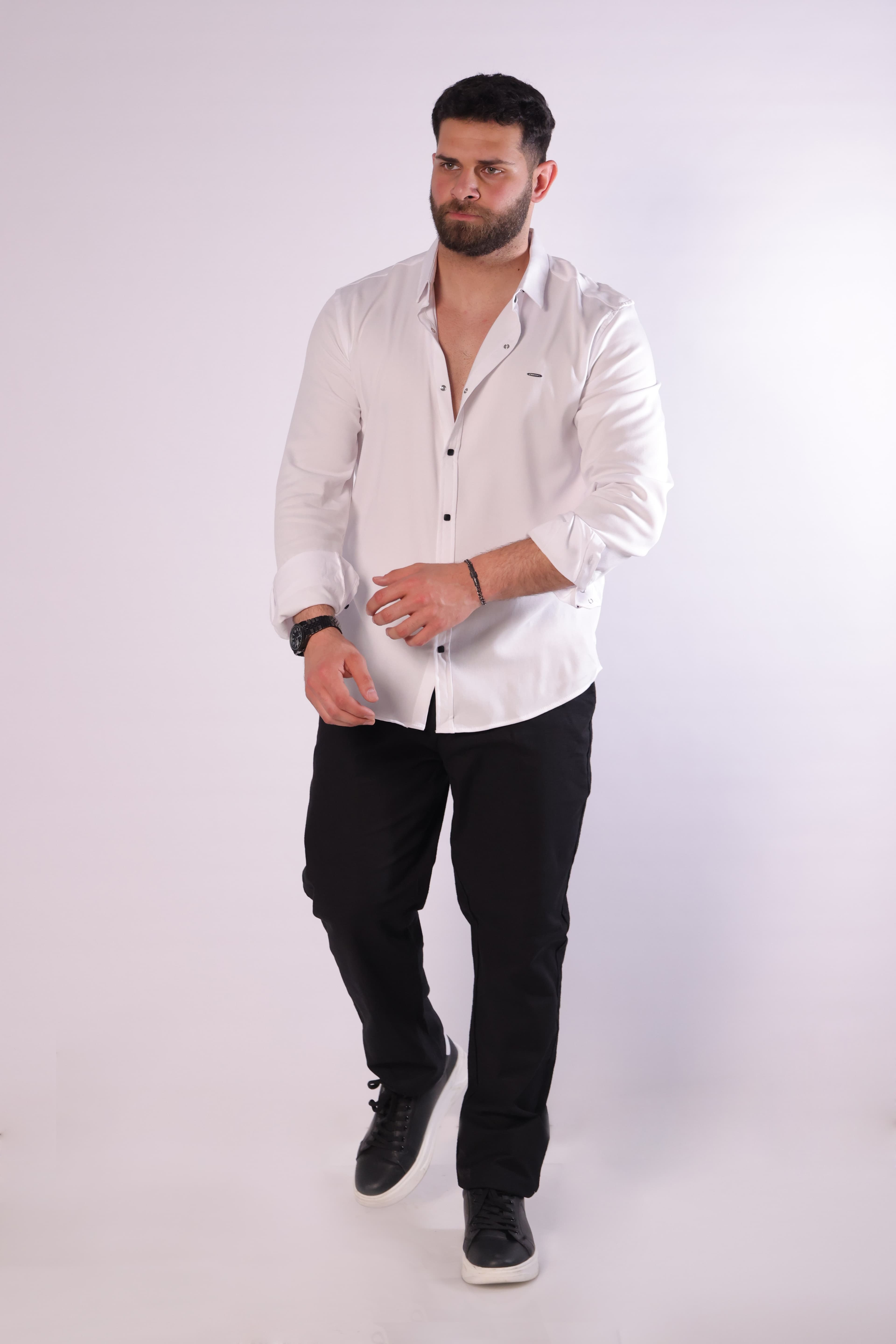 Slim-Fit White Button-Down Shirt - Slim-fit white button-down shirt designed for a clean, modern look. Featuring a sharp collar, minimal chest detailing, and contrasting dark buttons for a refined touch. Crafted from smooth, lightweight fabric that offers comfort and a polished finish—perfect for formal occasions or smart-casual styling.