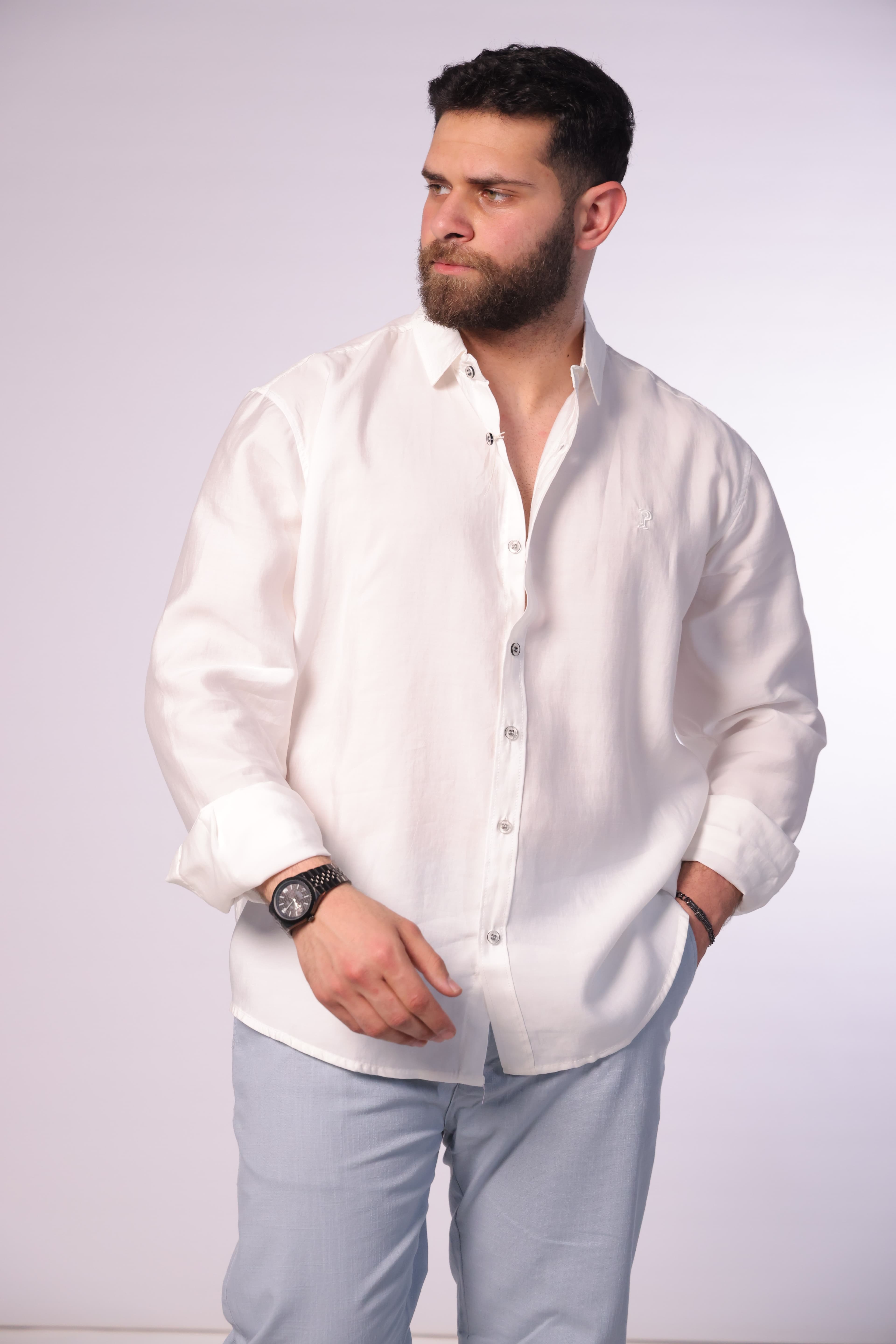 Relaxed-Fit White Button-Down Shirt - Relaxed-fit white button-down shirt designed for a clean and effortless look. Featuring a classic collar, full button closure, and subtle chest logo detailing for a minimal touch. Crafted from lightweight, breathable fabric with a soft feel, making it perfect for smart-casual outfits or laid-back everyday styling.