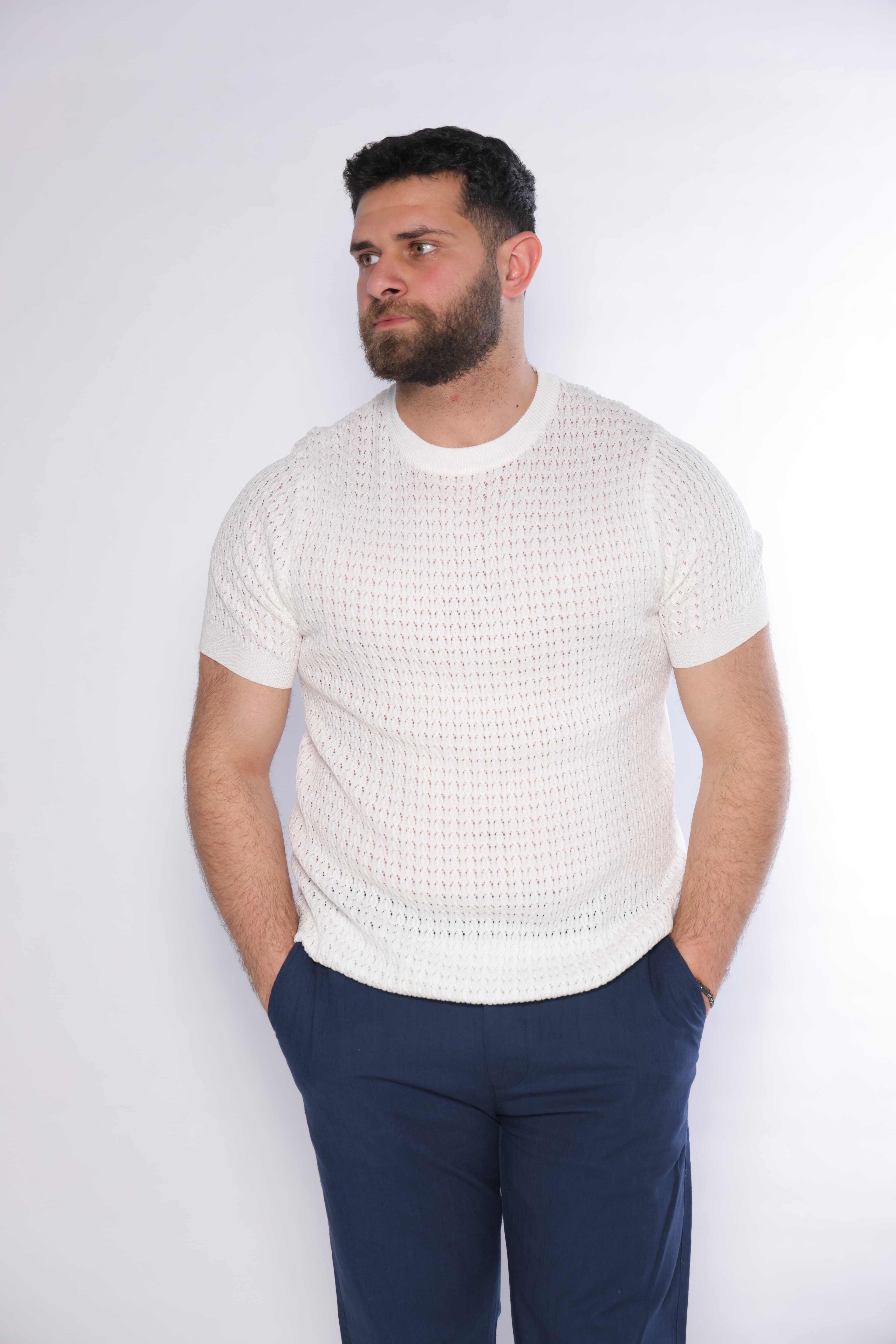 Slim-Fit White Knitted T-Shirt - Slim-fit knitted t-shirt in an elegant white tone, featuring a textured patterned weave that adds depth and a premium feel. Designed with a clean crew neckline and fitted short sleeves that highlight the silhouette. Crafted from soft, breathable fabric, making it perfect for smart-casual looks or elevated everyday wear.