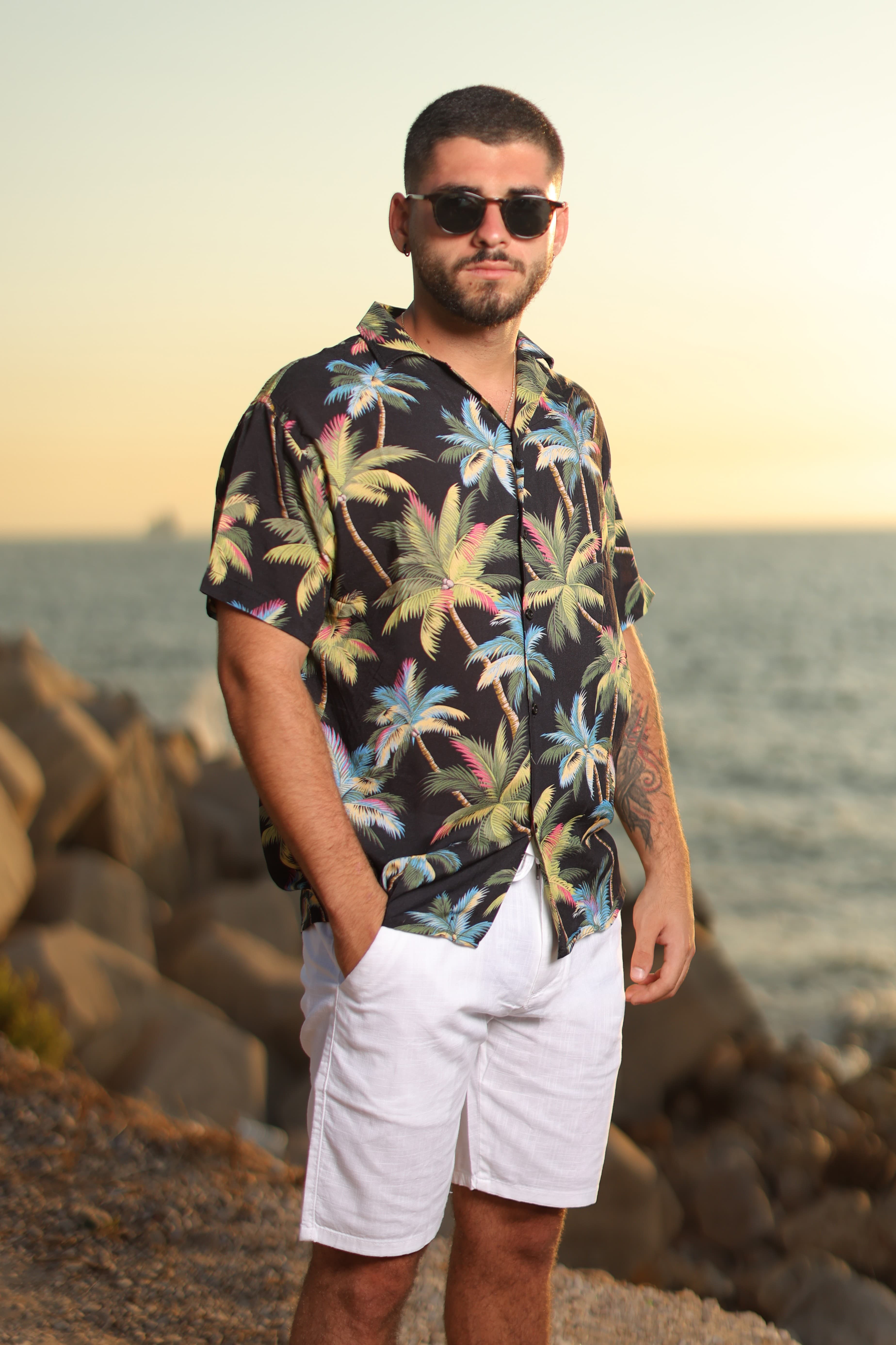 Relaxed-Fit Tropical Button-Down Shirt - Relaxed-fit short sleeve button-down shirt featuring a bold tropical palm print on a deep black base for a standout summer look. Designed with a camp collar and lightweight, breathable fabric for all-day comfort in warm weather. Perfect for beach days, vacations, or casual outings—bringing a vibrant, laid-back island vibe to your wardrobe.