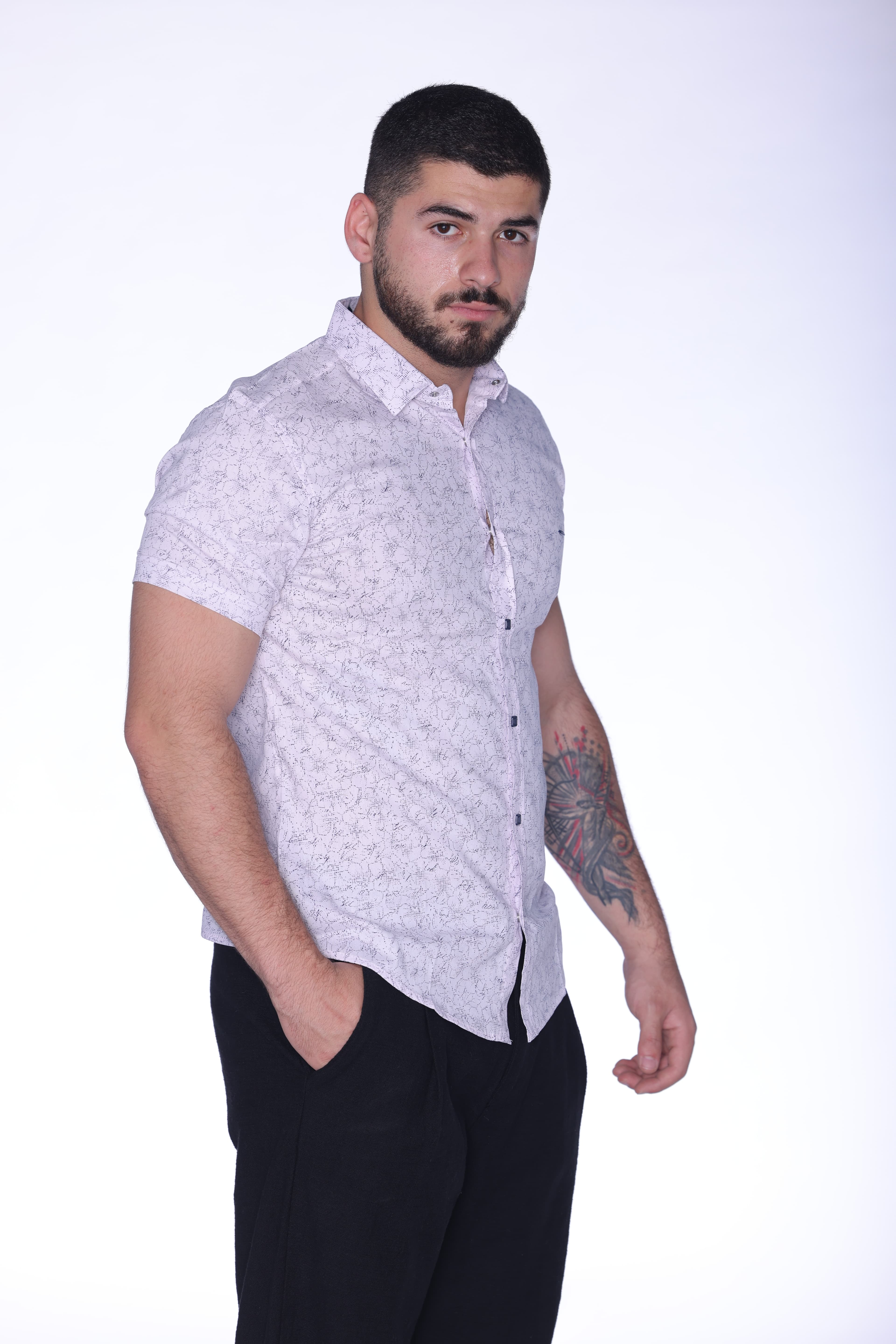 Slim-Fit Button-Down Shirt Light Pink - Slim-fit short sleeve button-down shirt in a light pastel tone, featuring a subtle all-over micro pattern for a refined and modern look. Designed with a sharp collar, clean front closure, and contrasting dark buttons for added detail. Crafted from lightweight, breathable fabric that ensures comfort while maintaining a sleek silhouette—perfect for smart-casual outfits or polished everyday wear.