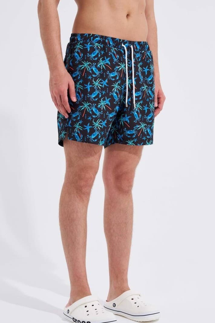 Tropical Print Swim Shorts - Tropical print swim shorts featuring a vibrant blue palm tree and crab pattern on a black base. Designed with an elastic waistband, adjustable drawstring, and lightweight quick-dry fabric for all-day comfort. Perfect for beach days, poolside looks, and summer vacations.