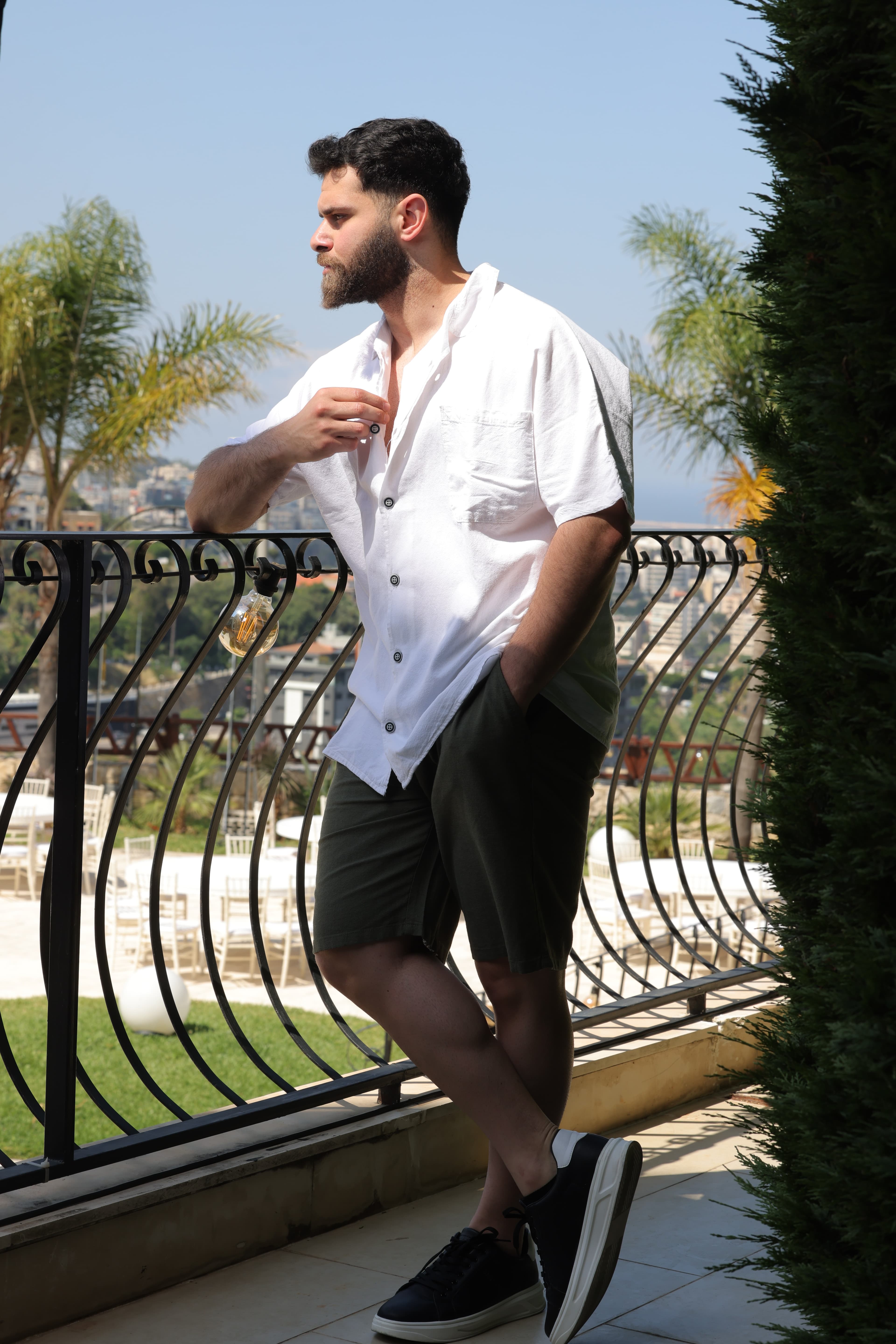 The Relaxed Fit White Shirt - Resort-ready with everyday versatility.

The relaxed fit of the open-collar white shirt paired with textured olive shorts creates an effortless Mediterranean-inspired silhouette. Minimal, confident, and perfect for warm summer days.